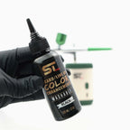 Supreme Trimmer washable black hair enhancement ink held by a barber for precise hairline and beard definition
