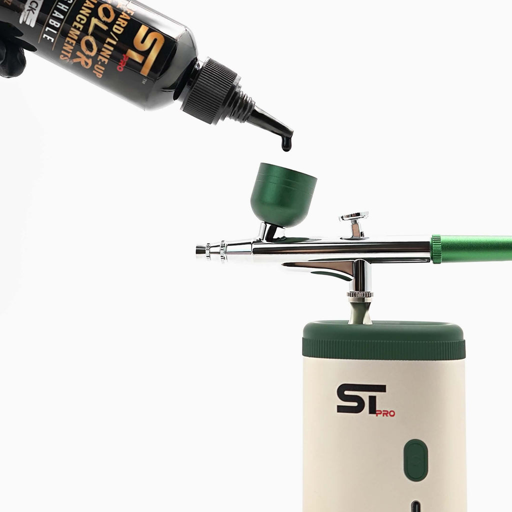 Supreme Trimmer washable black hair enhancement ink being poured into a professional barber airbrush gun