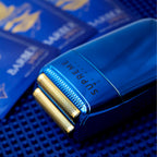 Blue electric shaver with gold accents on a blue barber matt