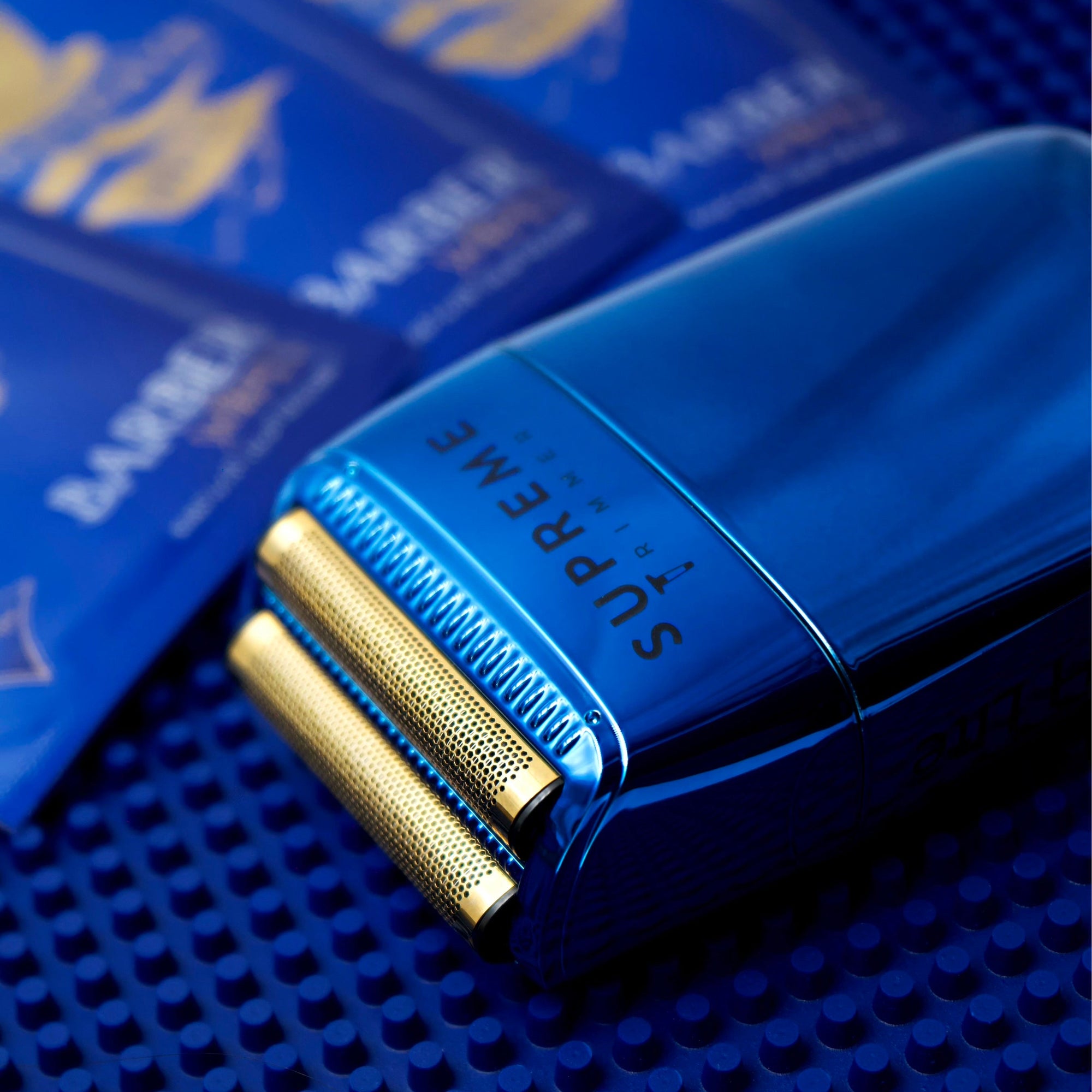 Blue electric shaver with gold accents on a blue barber matt
